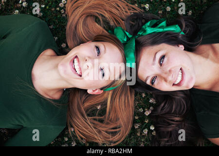 Due sorelle in verde su erba, il giorno di San Patrizio Foto Stock