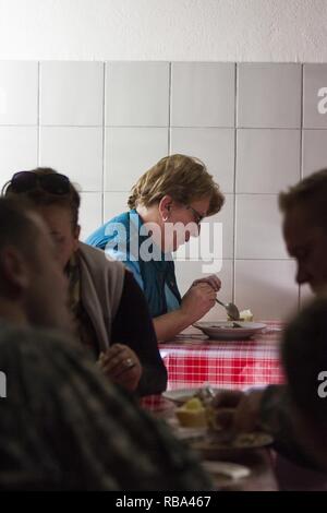 Shehide, un volontario a una donna rifugio a Pristina, Kosovo, prende un momento per godersi il suo pranzo dic. 20, 2016. Shehide il marito è stato ucciso e il suo figlio è stato preso durante la guerra alla fine degli anni novanta, lasciando il suo con quattro figlie di sollevare da solo. Ella volontari al rifugio per essere tra le altre donne che condividono le sue esperienze. Foto Stock