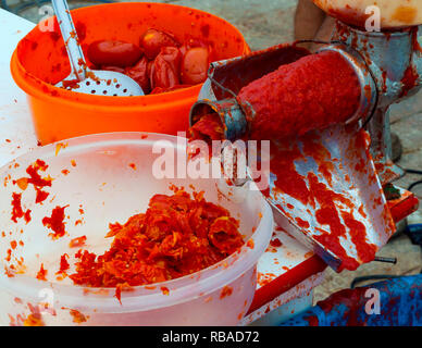 La spremitura di pomodori e preparare la passata di sugo di pomodoro (salsa) Foto Stock
