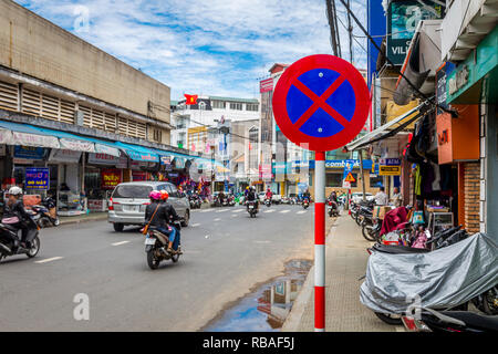 Da lat Vietnam intersezione segno come moto sono in strada con edifici su entrambi i lati. Foto Stock