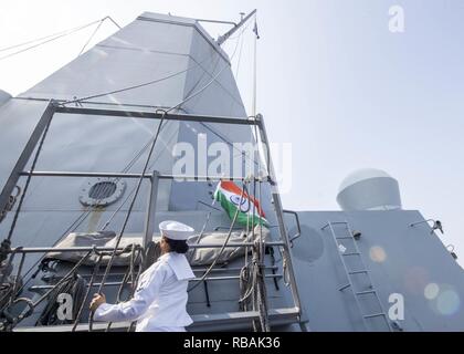 VISAKHAPATNAM, INDIA (dec. n. 22, 2018) Intendente di terza classe Jaquelyn R. Perriatt, da Los Angeles, solleva la bandiera indiana dal ponte ala del San Antonio-classe di trasporto anfibio dock nave USS ancoraggio LPD (23) durante una visita di porta a Visakhapatnam, India, mentre su una distribuzione dell'Essex anfibio gruppo pronto (ARG) e xiii Marine Expeditionary Unit (MEU). L'Essex ARG/ XIII MEU è un capace e letale Navy-Marine Corps team distribuiti per la 7a flotta area di operazioni a sostegno della stabilità regionale, rassicurare partner ed alleati e mantenere una presenza postured a rispondere a un Foto Stock