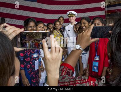 VISAKHAPATNAM, INDIA (dec. n. 23, 2018) Capt. Ray Owens, Addetto Navale presso l'ambasciata Usa a Nuova Delhi, in India, in posa per una foto con studenti di sesso femminile da San Giuseppe College in hangar bay a bordo del San Antonio-classe di trasporto anfibio dock nave USS ancoraggio LPD (23) durante una visita di porta a Visakhapatnam, India. Ancoraggio è su una distribuzione con la Essex anfibio gruppo pronto (ARG) e xiii Marine Expeditionary Unit (MEU). L'Essex ARG/ XIII MEU è un capace e letale Navy-Marine Corps team distribuiti per la 7a flotta area di operazioni a sostegno della stabilità regionale, rassicurare i partner Foto Stock