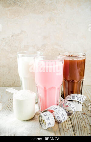 Sana dieta organici bere. Cioccolato, berry e vaniglia protein shake. Non proteina da latte vegan cocktail. Con nastro di misurazione. Concetto di peso los Foto Stock