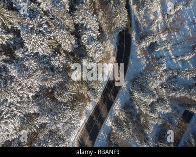 Strada diritta in montagna in inverno il paesaggio. Vista aerea della foresta Foto Stock