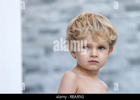 Funny bambino senza t-shirt in giardino Foto Stock