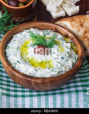 Salsa Tzatziki nella ciotola di legno. La cucina greca. Una sana alimentazione vegetariana. Messa a fuoco selettiva. Foto Stock