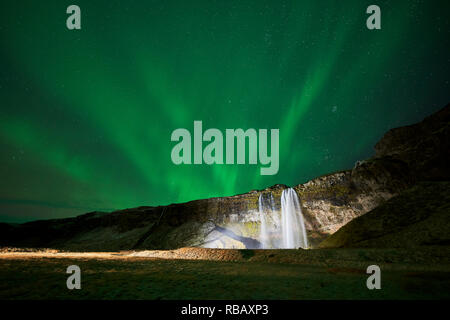 Cascata Seljalandsfoss e Aurora Boreale, Islanda Foto Stock