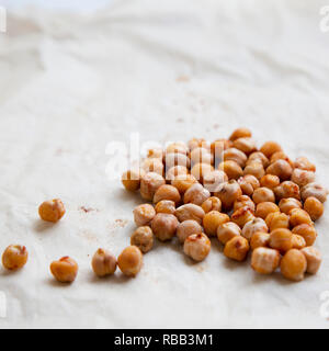 Ceci arrosto con spezie sulla carta da forno, close-up. Foto Stock