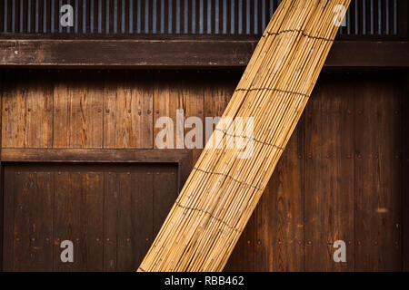 Schermata di bambù appoggiata sulla parete di legno in Tsumago Giappone Foto Stock