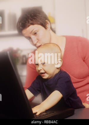La madre e il bambino figlio di un computer portatile godendo di tempo dello schermo insieme Foto Stock