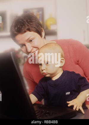 La madre e il bambino figlio di un computer portatile godendo di tempo dello schermo insieme Foto Stock