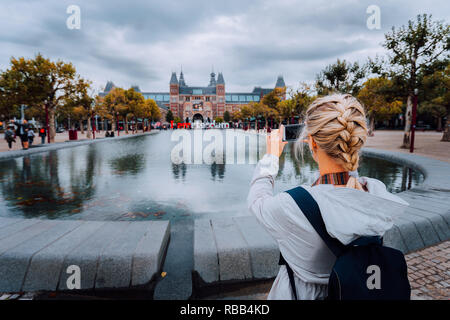 Donna turistica prendendo la foto del Rijksmuseum di Amsterdam sul telefono cellulare. Viaggi in Europa città concetto di viaggio Foto Stock