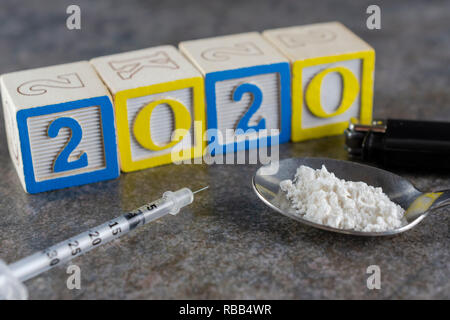 2020 Anno della droga? Siringa con un cucchiaio con polvere bianca (farina bianca per raffigurare le droghe illegali) e un accendino da vicino. Foto Stock