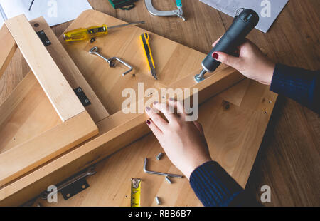 Gruppo donna mobili in legno,il fissaggio o la riparazione di casa con cacciavite tool.la vita moderna concetti idee Foto Stock