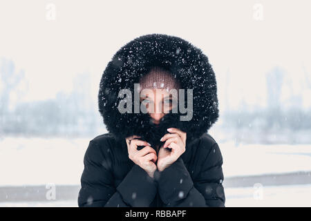 Donna che indossa hoodie mentre nevicava. Foto Stock