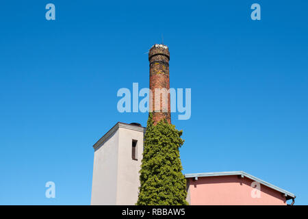 Vecchia ciminiera in mattoni contro il blu cielo senza nuvole. Foto Stock