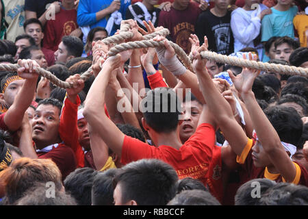 Manila, Filippine. 9 Gen, 2019. I devoti si combattono intorno cercando di toccare la corda che tira il carrello del Nazareno nero alla sua destinazione prevista in corrispondenza di Quiapo Chiesa. Una stima di 21 milioni hanno e stanno attualmente partecipanti il 2019 Festa del Nazareno Nero oggi, 9 gennaio. La festa commemora il trasferimento o la Traslacion dell immagine miracolosa del Nazareno nero dal San Nicolas De Tolentino a Intramuros al Quiapo Chiesa nell'anno 1787. Credito: Dennis Jerome Acosta/ Pacifico premere/Alamy Live News Foto Stock