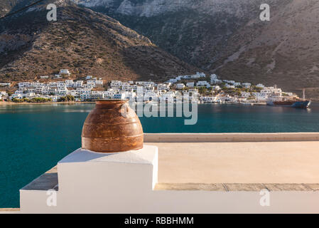 Greco tradizionale vaso di fiori sul tetto della casa che si affaccia sulla baia e il porto principale dell'isola di Sifnos. La Grecia Foto Stock