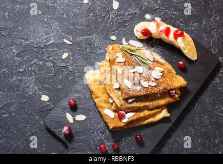 Crepes tradizionali con banana e bacche nere su sfondo di pietra. Spazio di copia Foto Stock