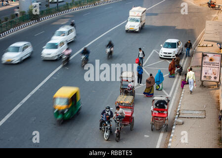 Il traffico in movimento di fronte a una fermata nei pressi Sarita Vihar Stazione della Metropolitana, New Delhi Foto Stock