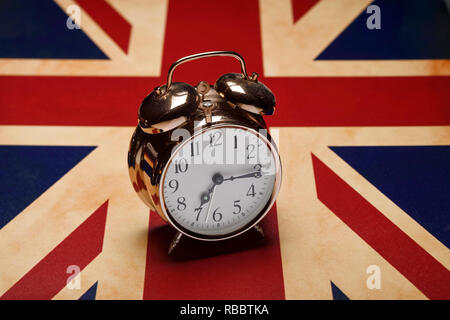 Un tradizionale sveglia seduto su una bandiera dell'Union Jack Foto Stock