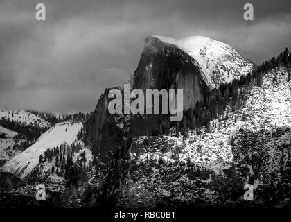 Vista ravvicinata della mitica Half Dome, nel torbido inverno tempesta di neve - bianco e nero. Foto Stock