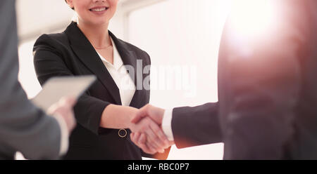 Imprenditrice stringono le mani con un businssman durante una riunione Foto Stock