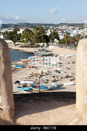 Tra le forchette della fortezza si ha vista sulla città, montagna, barche e persone sulla spiaggia di sabbia Hammamets Foto Stock