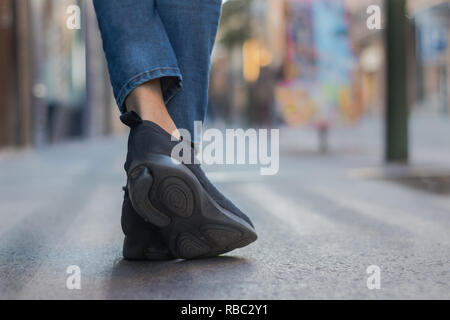 Gambe con jeans e tela nera sneakers nella città, lo stile di vita Foto Stock