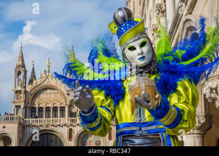 Carnevale a Venezia. Una bella maschera veneziana mostra la famosa città di fronte Palazzo Ducale e la Basilica di San Marco Foto Stock