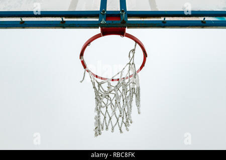 Congelati outdoor Basketball hoop in inverno la neve sul vuoto sport parco giochi Foto Stock