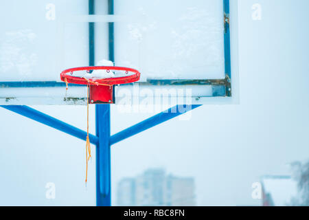 Congelati outdoor Basketball hoop in inverno la neve sul vuoto sport parco giochi Foto Stock