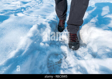 Uomo a camminare nella neve, escursioni e trekking in inverno Foto Stock