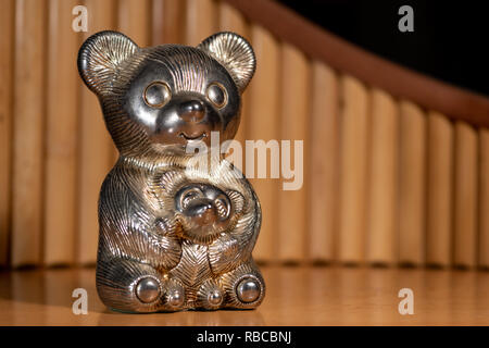 Figura metallico di una grande e una piccola poggiano su di un tavolo di fronte a un flauto di pan Foto Stock