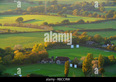 Sole di sera nel corso di un tradizionale villaggio inglese campo da cricket. Foto Stock