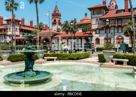 Sant'Agostino, Stati Uniti d'America - 10 Maggio 2018: Flagler College con architettura della Florida, la famosa statua in città storica, fontana e trolley tour guida tr Foto Stock