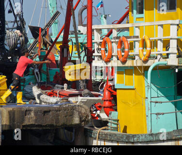 Pescatore di cattura di scarico dalla barca da pesca a wharf, Kota Kinabalu, Sabah (Borneo), Malaysia Foto Stock