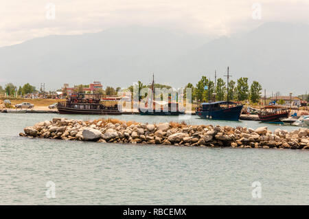 Paralia, Grecia - 13 Giugno 2013: pietre di mare marina, turistica e per i pescatori di barche e navi in piccola baia e monte Olympus sullo sfondo Foto Stock