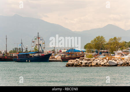 Paralia, Grecia - 13 Giugno 2013: pietre di mare marina, turistica e per i pescatori di barche e navi in piccola baia, le attrazioni della città e il monte Olympus sulla ba Foto Stock