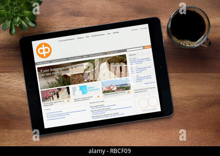 Il sito web di OP Gruppo finanziario (OP-Pohjola) è visto su un tablet iPad, appoggiato su una tavola di legno (solo uso editoriale). Foto Stock