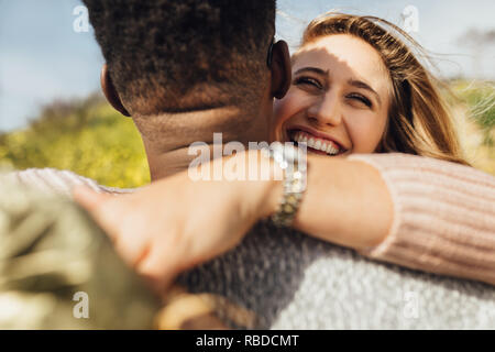 Matura in amore in piedi all'esterno. Donna mettendo le braccia intorno al suo fidanzato e ridere. Foto Stock
