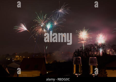 Immagine a colori con fuochi d'artificio su Mainz, Germania, due bicchieri di champagne sfumata nella parte anteriore Foto Stock