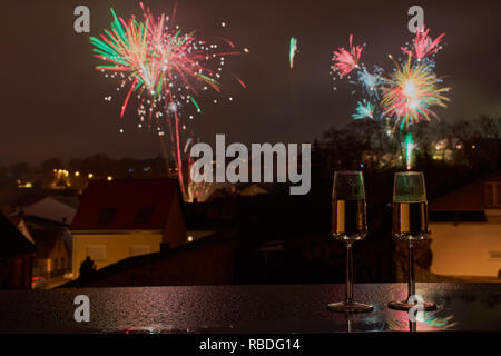 Orizzontale delle immagini a colori di due bicchieri di vino spumante, sullo sfondo sfocato fuochi d'artificio Foto Stock