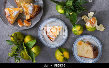 Tangerine torta sulla pietra grigia sfondo, vista dall'alto, laici piatta Foto Stock