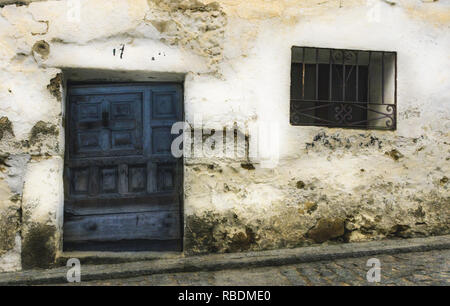Vecchio Blu porta in legno e ferro battuto finestra sul bianco muro di calce, Pedro Bernardo, Avila, Spagna Foto Stock