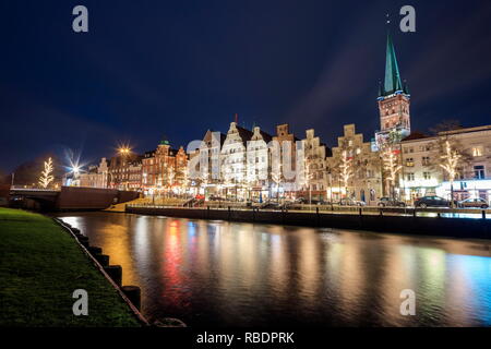 Vista notturna di tipiche case e la cattedrale si riflette nel fiume Trave a Lubecca, Schleswig Holstein Germania Europa Foto Stock