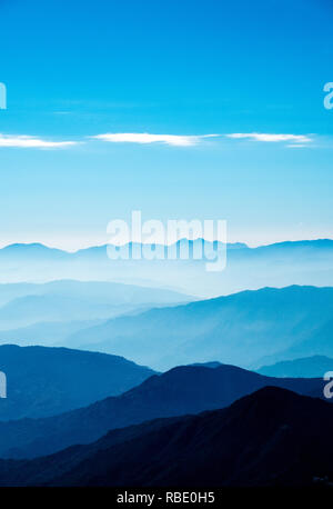 Un'alba nebbiosa nell'Himalaya del Nepal con valli e colline piene di nebbia che si allontanano in lontananza Foto Stock