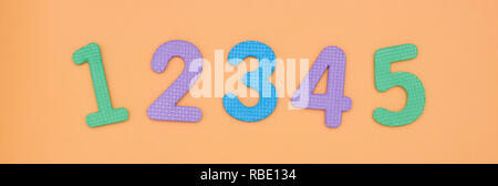 Luminose e camere per bambini da 1 a 5 sono realizzati di colore schiuma bambino isolato su sfondo di pesche. numeri colorati. Foto Stock