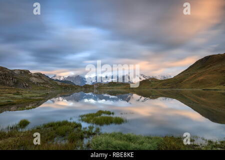 Le cime innevate sono riflesse nei laghi Fenetre all'alba Ferret Valley Saint RhÃ©mio Gran San Bernardo Valle d'Aosta Italia Europa Foto Stock
