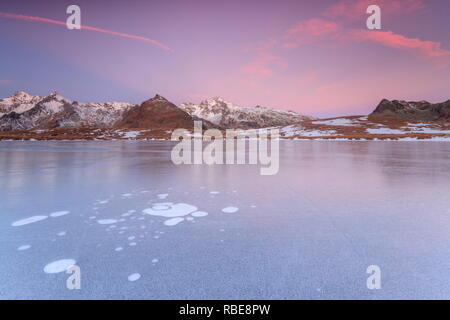 Bolle di ghiaccio sulla superficie ghiacciata del lago Andossi a sunrise Valle Spluga Valtellina Lombardia Italia Europa Foto Stock